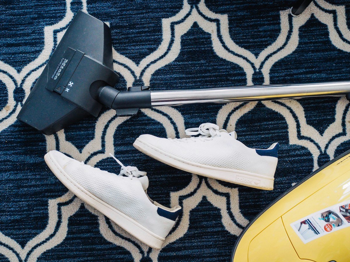 Spring cleaning with a vacuum and white sneakers